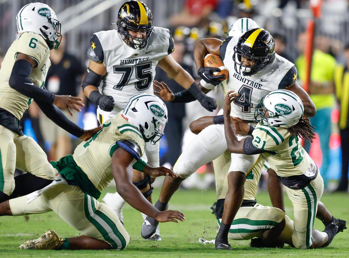 American Heritage running back Mark Fletcher (4) earns a first down as Miami Central’s Amari Wallace (21) makes the tackle in the first quarter during the 2022 FHSAA State Championships-Class 2M at DRV PNK Stadium in Ft. Lauderdale on Friday, December 16, 2022.