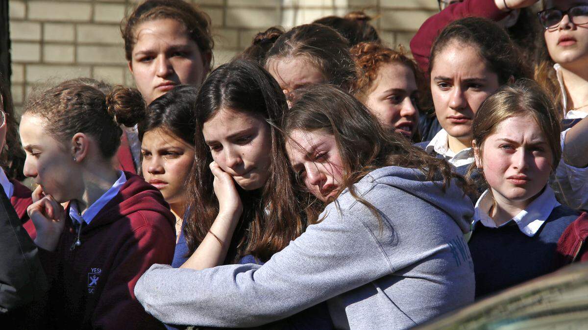 Students from the Yeshiva School in the Squirrel Hill neighborhood of Pittsburgh stand outside Beth Shalom Synagogue on Wednesday after attending the funeral service for Joyce Fienberg, 75, one of 11 people killed when a gunman opened fire during worship services at the Tree of Life Synagogue on Oct. 27.