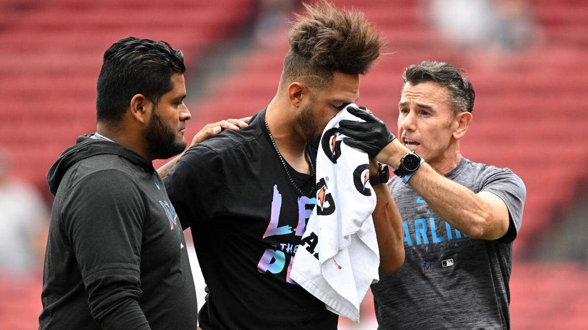 Miami Marlins first baseman Yuli Gurriel (10) is helped off of the field after an injury during warmups before a game against the Boston Red Sox at Fenway Park.