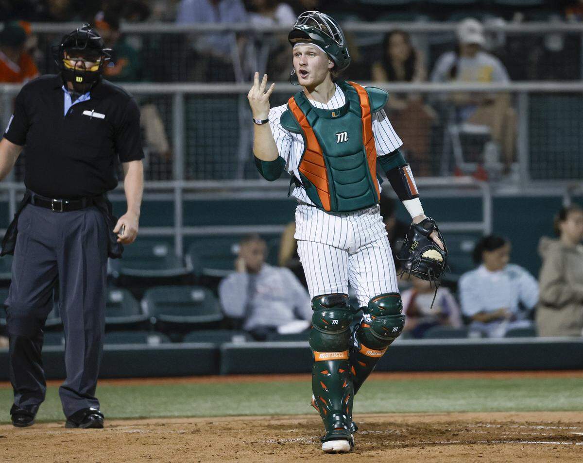 Miami Hurricanes catcher Alex Sosa (13) signals towards the dug out during the Hurricanes season opener against the Lehigh Mountain Hawks at Mark Light Field in Coral Gables, Florida, Florida on Friday, February 13, 2026