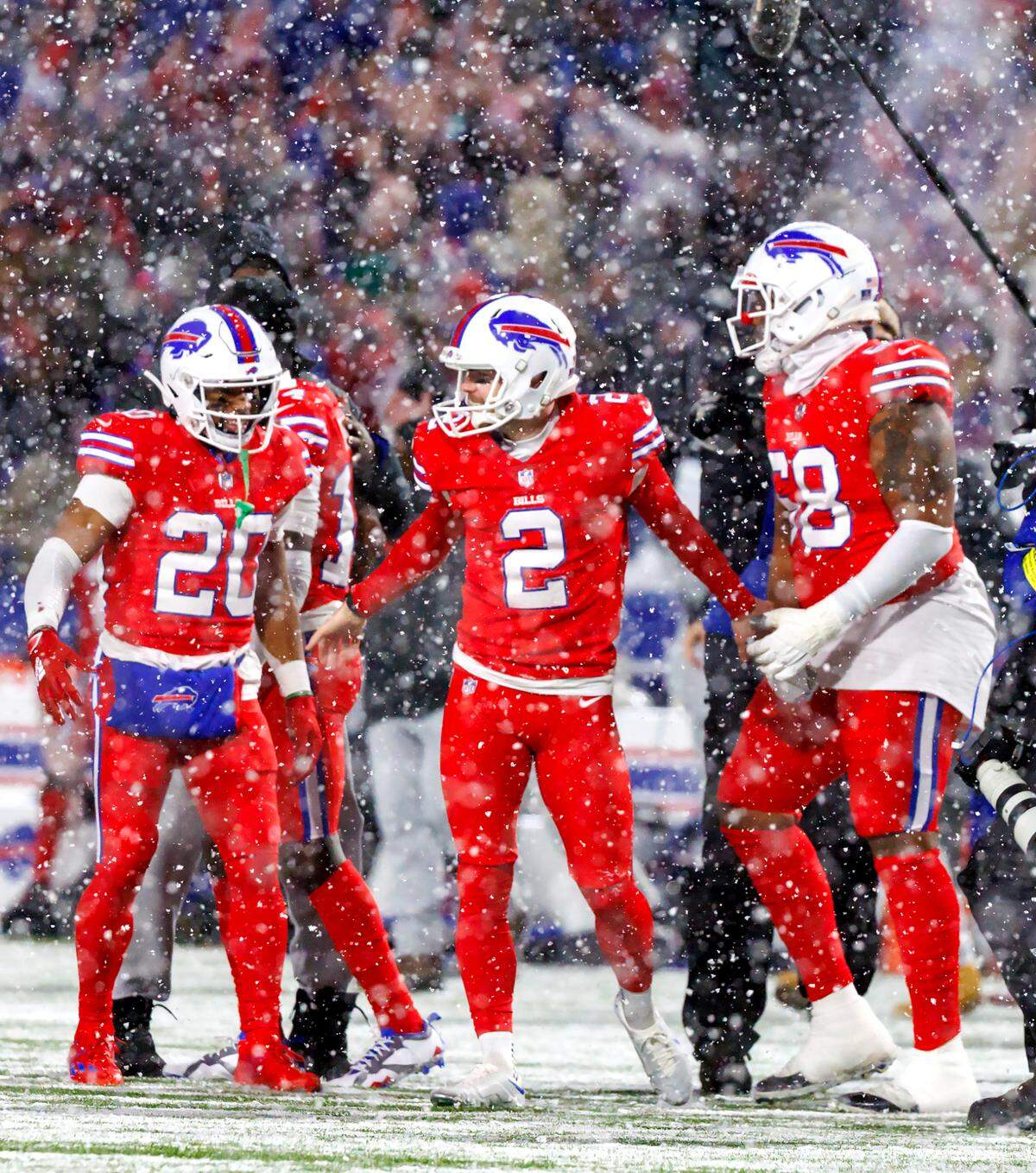 Buffalo Bills place kicker Tyler Bass (2) celebrate with teammates Nyheim Hines (20) and Bobby Hart (68) after kicking 25 yard field goal to win the game during fourth quarter of an NFL football game against the Miami Dolphins at Highmark Stadium on Saturday, December 17, 2022 in Orchard Park, New York.