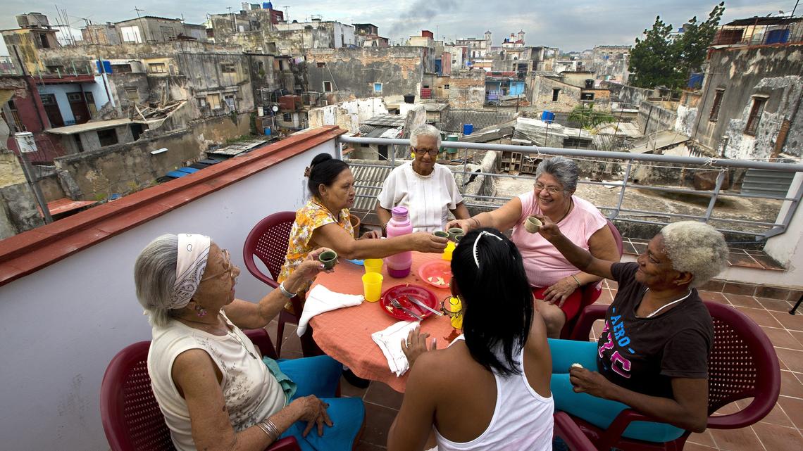 Elderly participants in the Circulo de Abuelos program at Nuestra Señora de la Merced church in Old Havana toast each other with coffee on the rooftop of the elderly center. Cuba has the oldest population in the Americas.