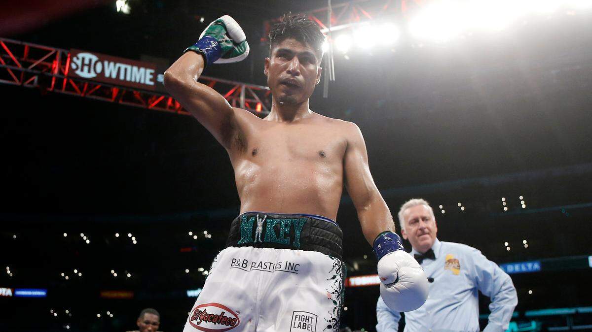 Mikey Garcia, center, raises his arm after the 11th round against Robert Easter Jr., left, during their WBC and IBF world lightweight title bout in Los Angeles, Saturday, July 28, 2018. At right is Judge Jack Reiss. Garcia won by unanimous decision.