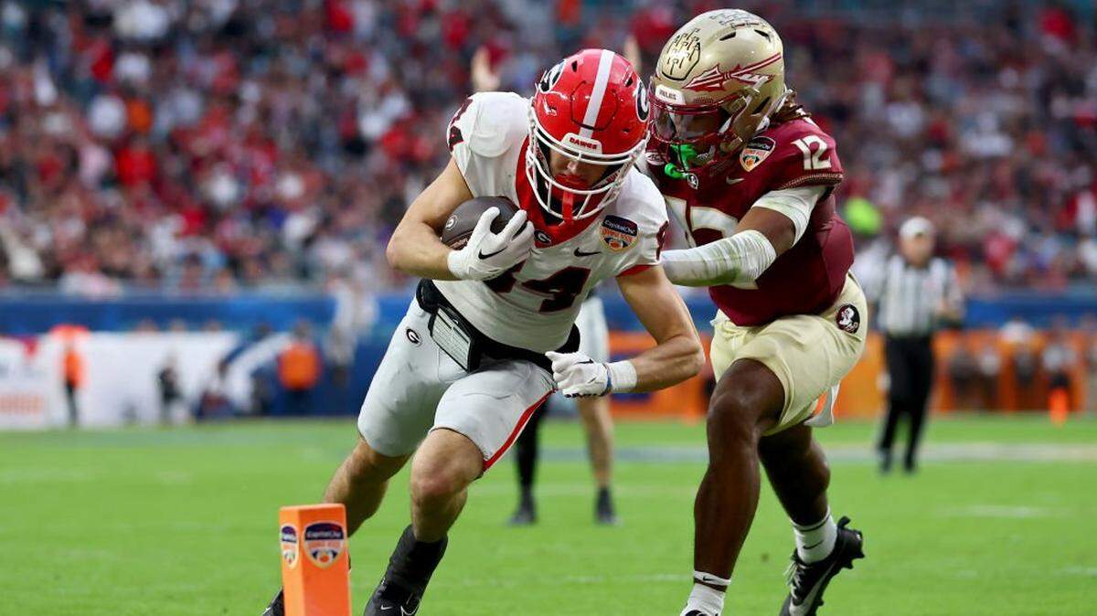 MIAMI GARDENS, FLORIDA - DECEMBER 30: Ladd McConkey #84 of the Georgia Bulldogs scores a touchdown past Conrad Hussey #12 of the Florida State Seminoles in the second quarter  during the Capital One Orange Bowl at Hard Rock Stadium on December 30, 2023 in Miami Gardens, Florida. (Photo by Megan Briggs/Getty Images)