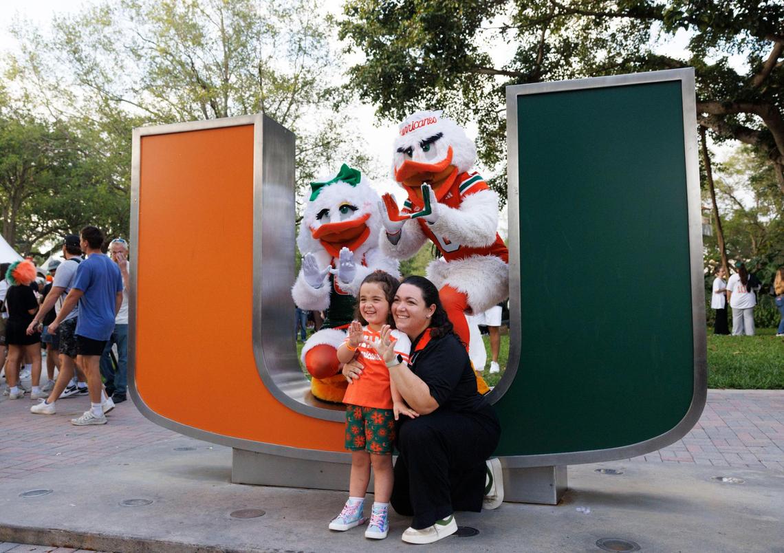 Elena Rovira, right, alumni, poses with her daughter, Maddie, 5, and mascot Sebastian and Gigi, his partner, inside the U during the University of Miami Centennial celebration on Tuesday, April 8, 2025, on Foote University Green at the University of Miami’s Coral Gables campus.