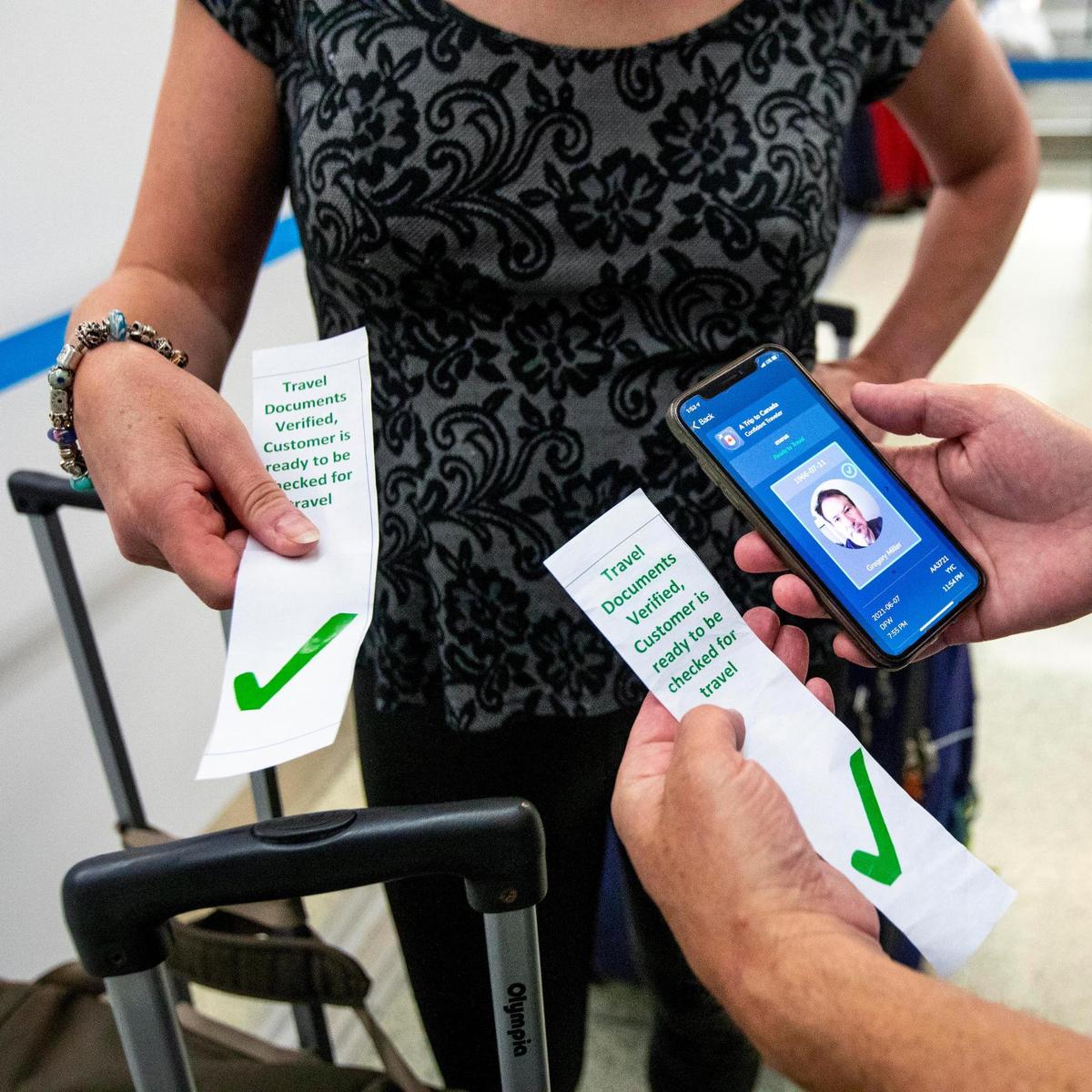 Canadian citizens Patty and Greg Miller show how they checked in, using VeriFLY, a smartphone app that lets people upload documentation proof of negative COVID test or vaccine proof, before their international flight from Miami International Airport in Miami, Florida, on Monday, June 7, 2021.