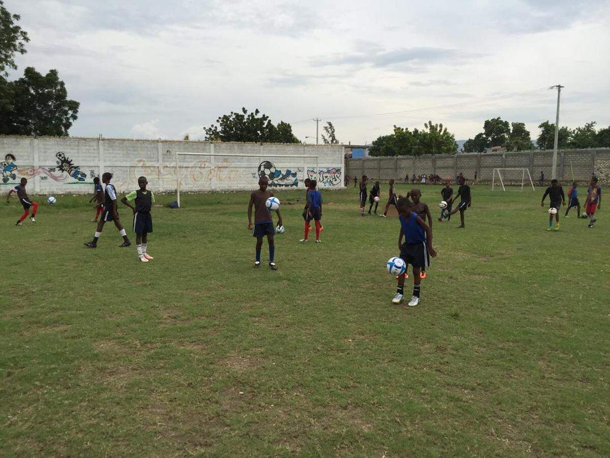 Olympique École de Football in Sarthe, Haiti provides children from some of Haiti’s poorest neighborhoods with the chance to envision another life from the hardships they know. The program recently lost its goalkeeper, Josué St. Vilus,, 11, who was killed on Saturday, May 16, 2026 when a stray bullet tore through his abdomen as his family tried to flee gang attacks.