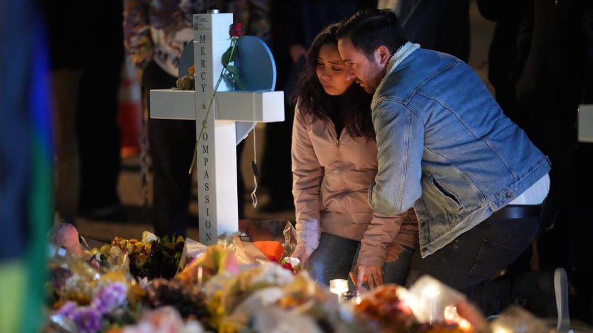 People embrace during a candlelight vigil near the site of a recent mass shooting at a gay club in Colorado Springs, Colorado.