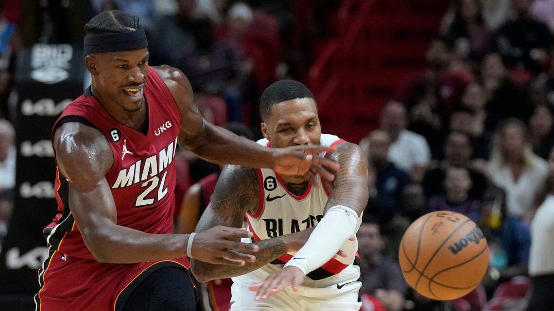Miami Heat forward Jimmy Butler (22) and Portland Trail Blazers guard Damian Lillard (0) battle for a loose ball during the second half of an NBA basketball game, Monday, Nov. 7, 2022, in Miami.