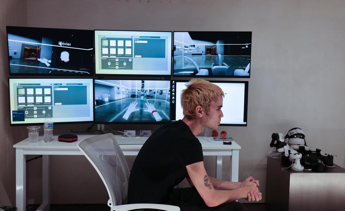 Abraham Lopez, user experience success agent for Miami’s Yupix, sits next to display screens while he waits to assist a group taking a virtual property tour of the new Waldorf Astoria high-rise under construction in downtown Miami. The screens showed the actual images projected by individuals wearing virtual reality headsets.