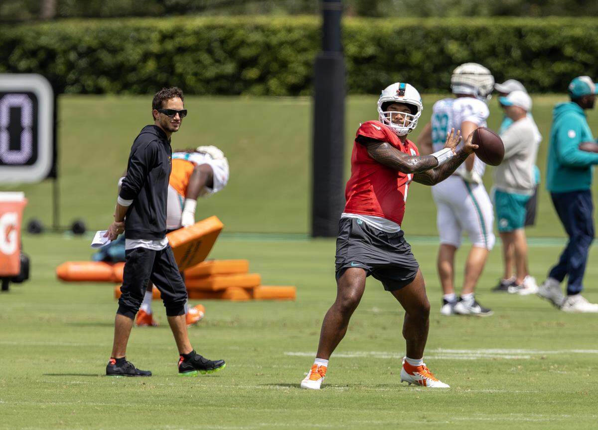 Miami Dolphins quarterback Tua Tagovailoa (1) set up to pass during practice as head coach Mike McDaniel looks on at the Baptist Health Training Complex in Miami Gardens, Fla., Thursday, Sept. 25, 2025.
