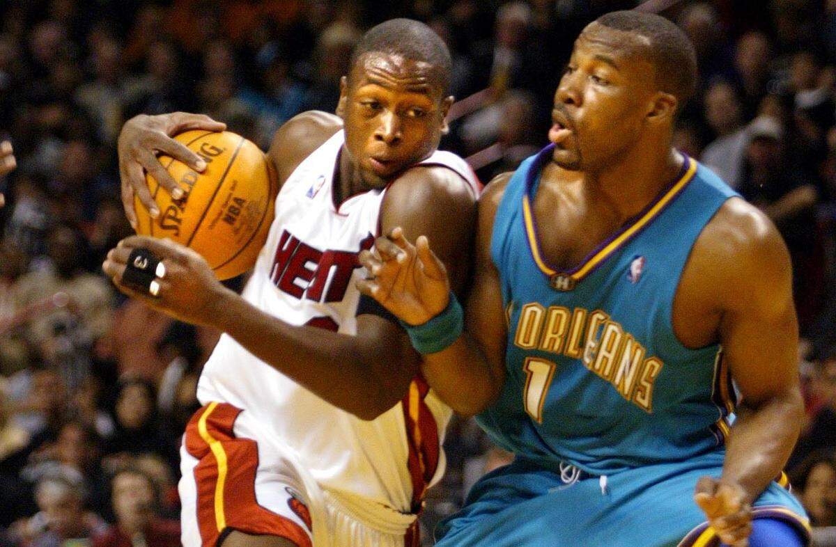Heat’s Dwayne Wade drives to the basket as Hornets Baron Davis defends during his playoff debut on Sunday April 18, 2004.