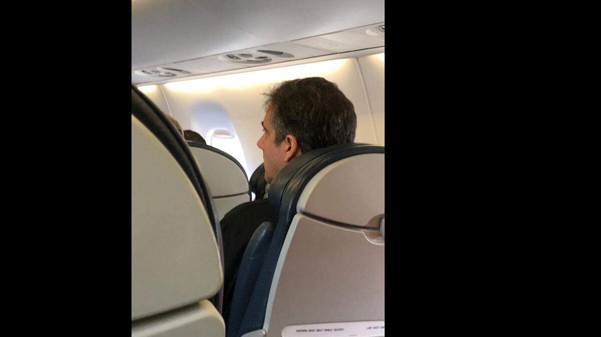Michael Cohen sits in economy class on an American Airlines flight from New York to Miami Friday morning.