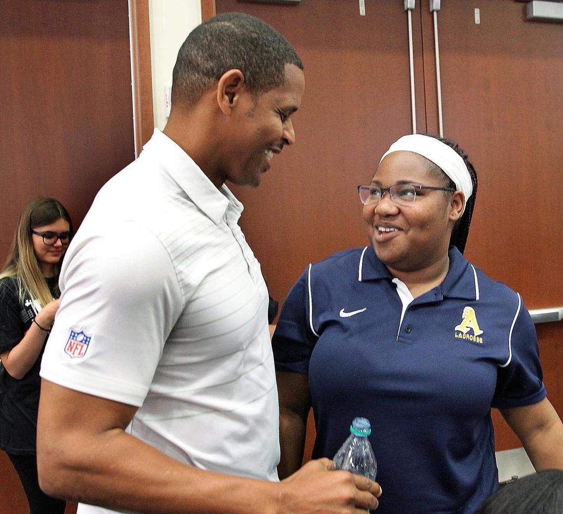 Former Miami Dolphins linebacker Twan Russell greets Kayla Scott at the University of Miami Newman Alumni Center on Friday, June 22, 2018.