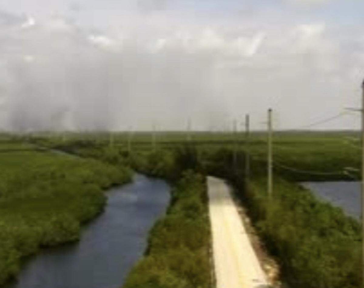 Smoke is seen in the distance in a photo from a Florida Department of Transportation traffic camera overlooking Card Sound Road Monday, May 3, 2021.