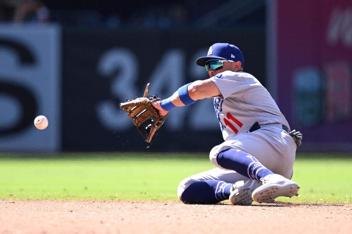 Aug 7, 2023; San Diego, California, USA; Los Angeles Dodgers shortstop Miguel Rojas (11) fields a ground ball against the San Diego Padres during the ninth inning at Petco Park.