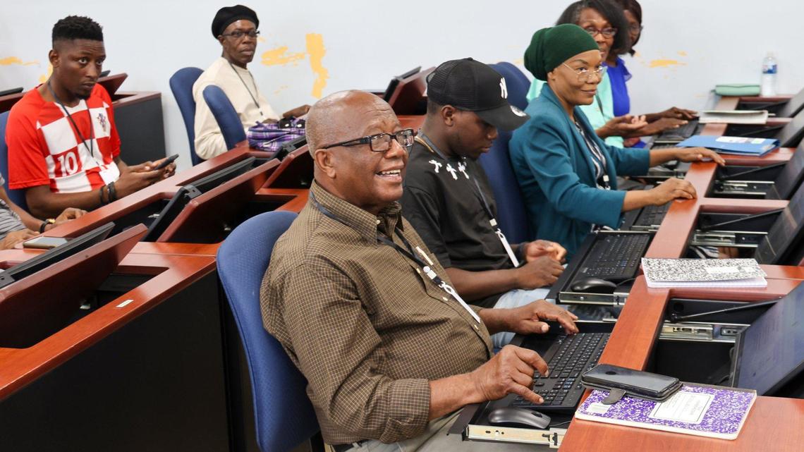 Joseph Jean-Baptiste, 77, center, smiles as he listens as adult Haitian students attended a computer class at the Pierre Toussaint Leadership and Learning Center in the Little Haiti neighborhood of Miami, Florida, to learn digital skills and ease the pathway into employment on Wednesday, September 25, 2024.