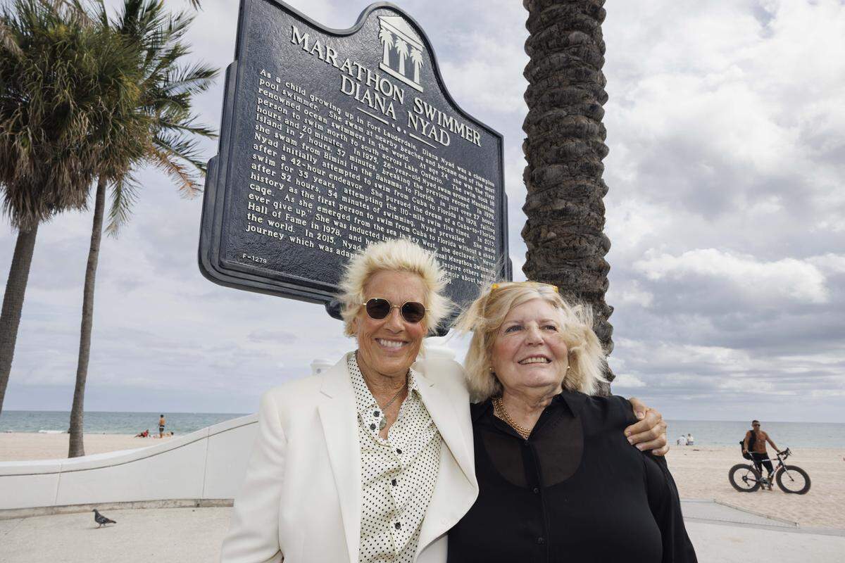 Diana Nyad, left, poses with Dr. Lynette Long, the one who spearheaded the effort, and the street marker on Las Olas named after Nyad on Thursday, Nov. 6, 2025, at Las Olas Oceanside Park in Fort Lauderdale, Fla.