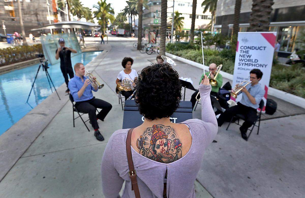 A woman stops to guest conduct as musicians from the New World Symphony hold an interactive concert on Lincoln Road. Miami Beach Commissioner John Elizabeth Alemán said she wants to bring more music to Miami Beach by allowing restaurants to more easily hire musicians.