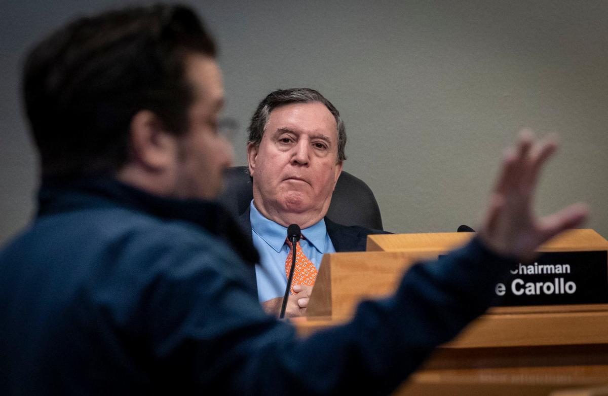 Commissioner Joe Carollo listens to filmmaker Billy Corben during the public comment portion of a meeting on May 23, 2024.
