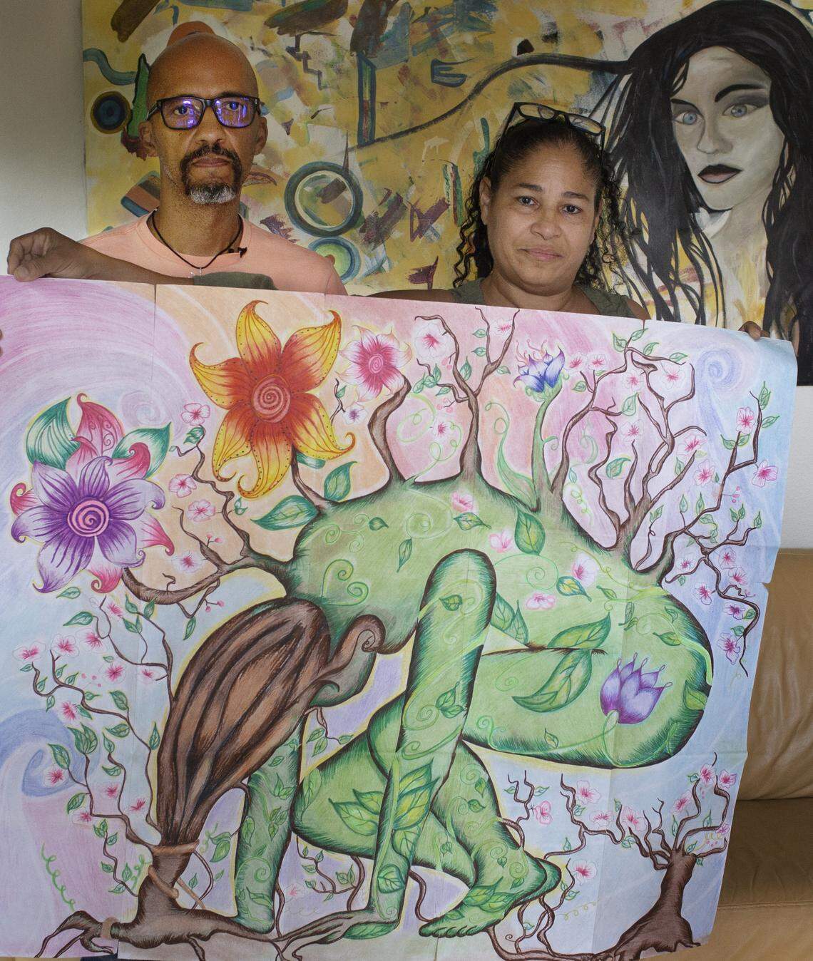 Jomari DeLeon’s parents, Robert Betancourt, 59, and Marina Vega, 57, hold a painting their daughter sent them from prison in their Kissimmee home September 12, 2019. “This painting hit us emotionally because it kind of expresses the way we all feel. It kind of reflects being drug down by everything — including the court system,” Betancourt said.