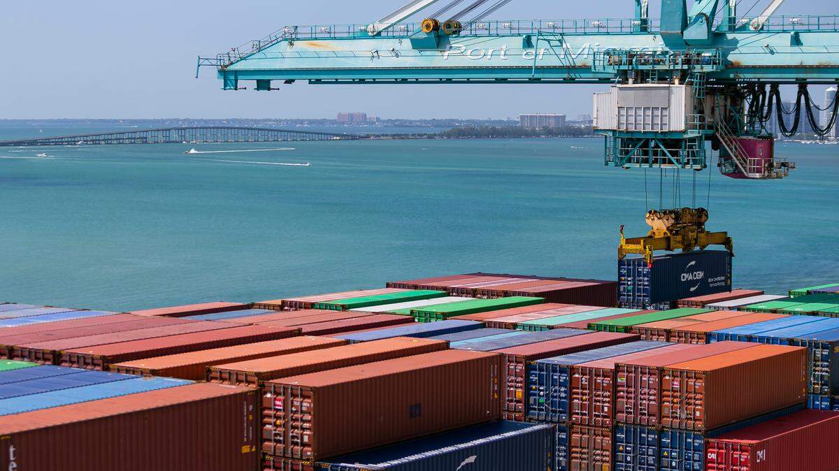 A longshoreman operates a gantry to offload containers from a docked cargo ship at PortMiami on Saturday, Feb. 20, 2021.