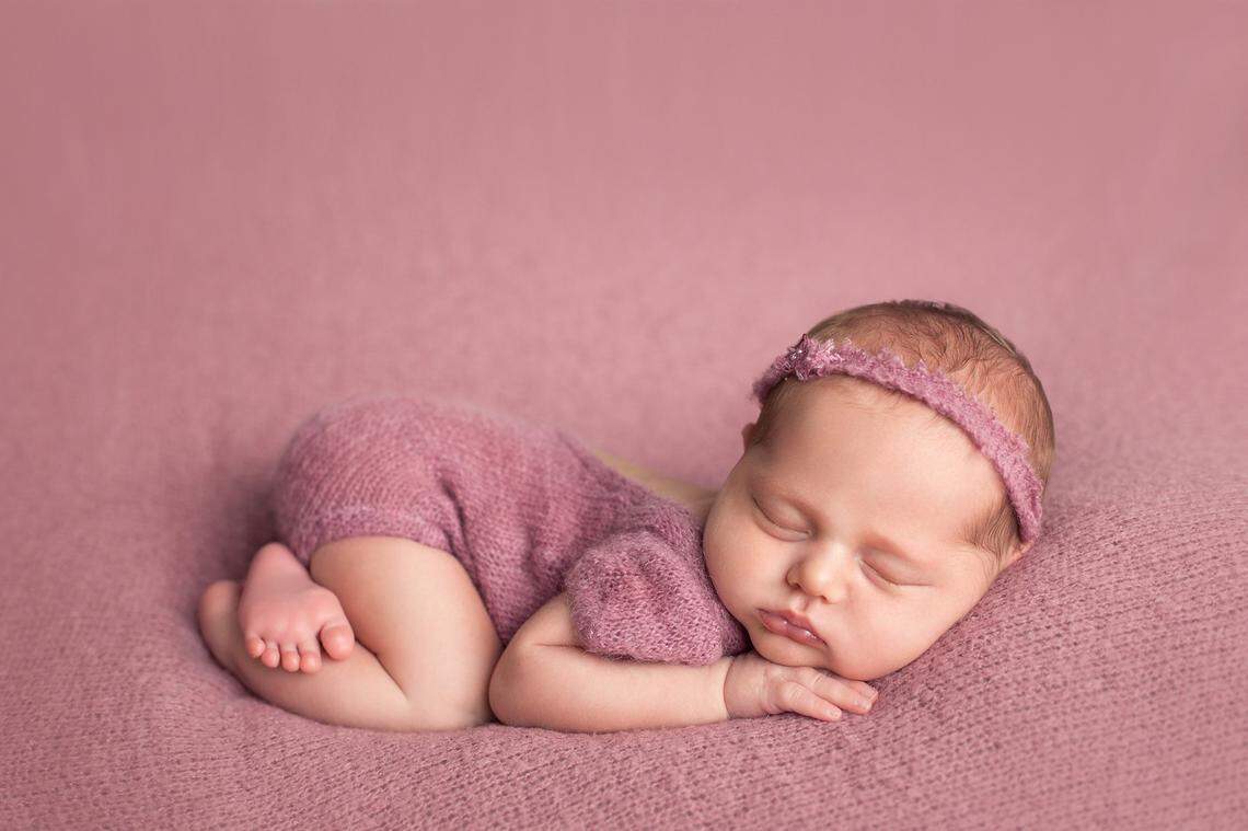 newborn baby girl pink background