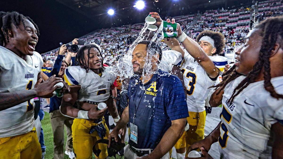 St. Thomas Aquinas coach Roger Harriott gets doused with water as the Raiders celebrate defeating Tampa Bay Tech in the FHSAA Class 7A State Championship at DRV PNK Stadium, in Fort Lauderdale on Friday, December 17, 2021.