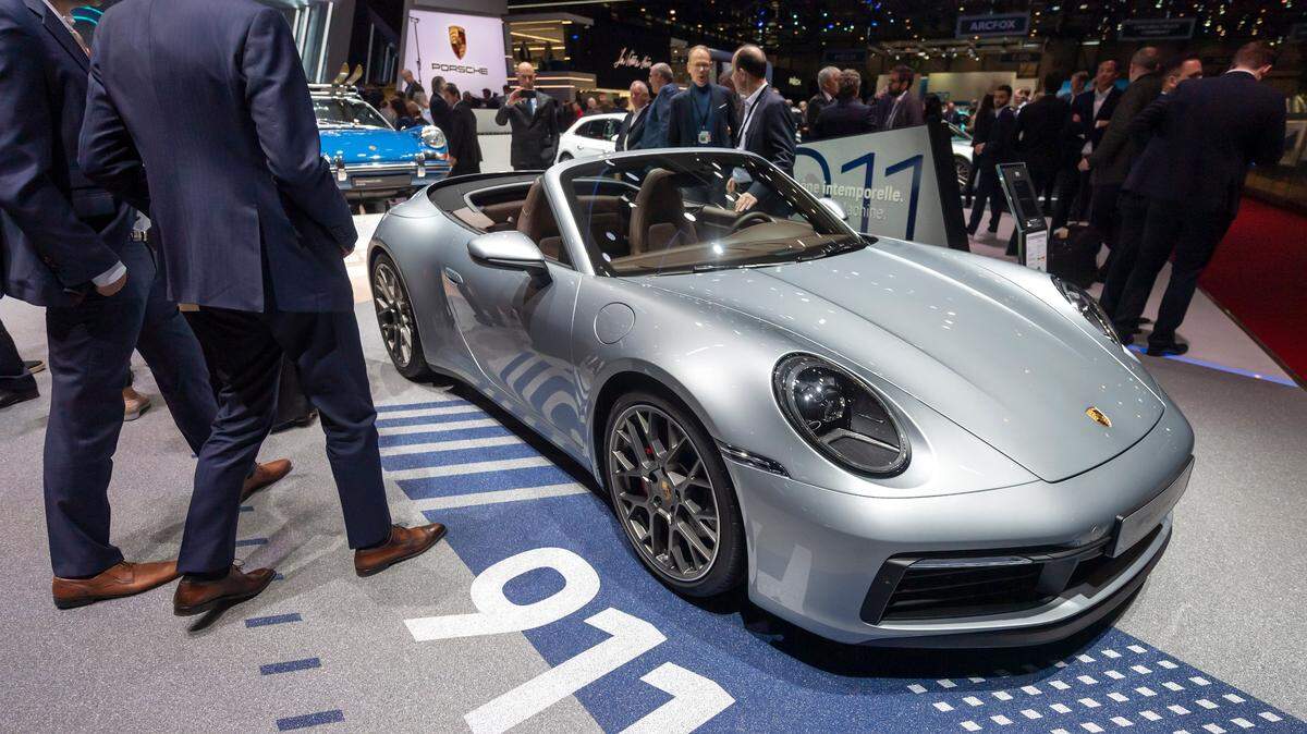 Visitors look at the new ‘Porsche 911 Carrera S’ during the ’89th Geneva International Motor Show’ in Geneva, Switzerland, on March 05, 2019. A former car salesman was arrested on charges of selling rare, non-existent Carrera 911 models to more than 30 customers who paid him $2.2 million toward the “bogus” sales.
