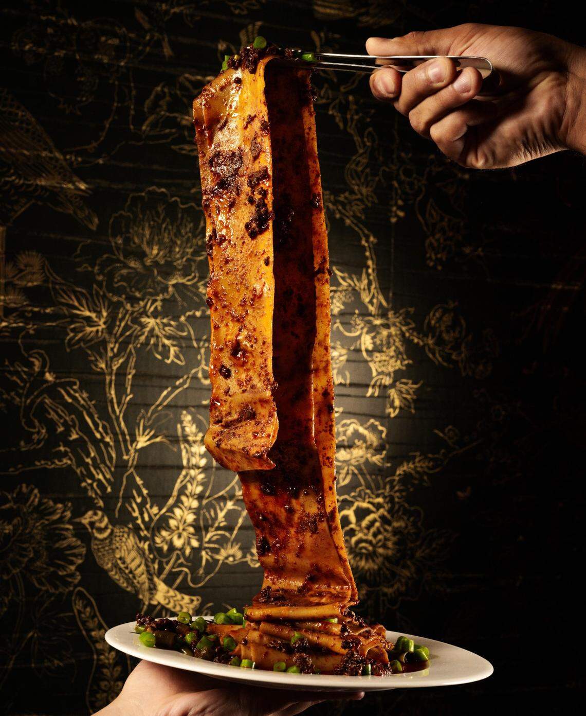 The four foot belt noodle coated in chili oil at Mimi’s Chinese in Miami Beach.