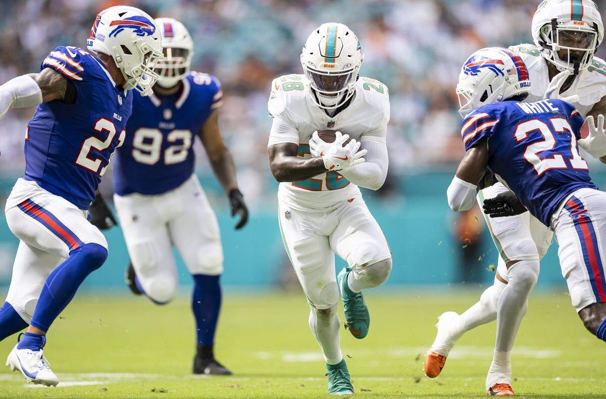 Miami Dolphins running back De'Von Achane (28) is tackled by Buffalo Bills safety Jordan Poyer (21) and cornerback Tre'Davious White (27) in the first half of their NFL game at Hard Rock Stadium on Sunday, Nov. 9, 2025, in Miami Gardens, Fla.