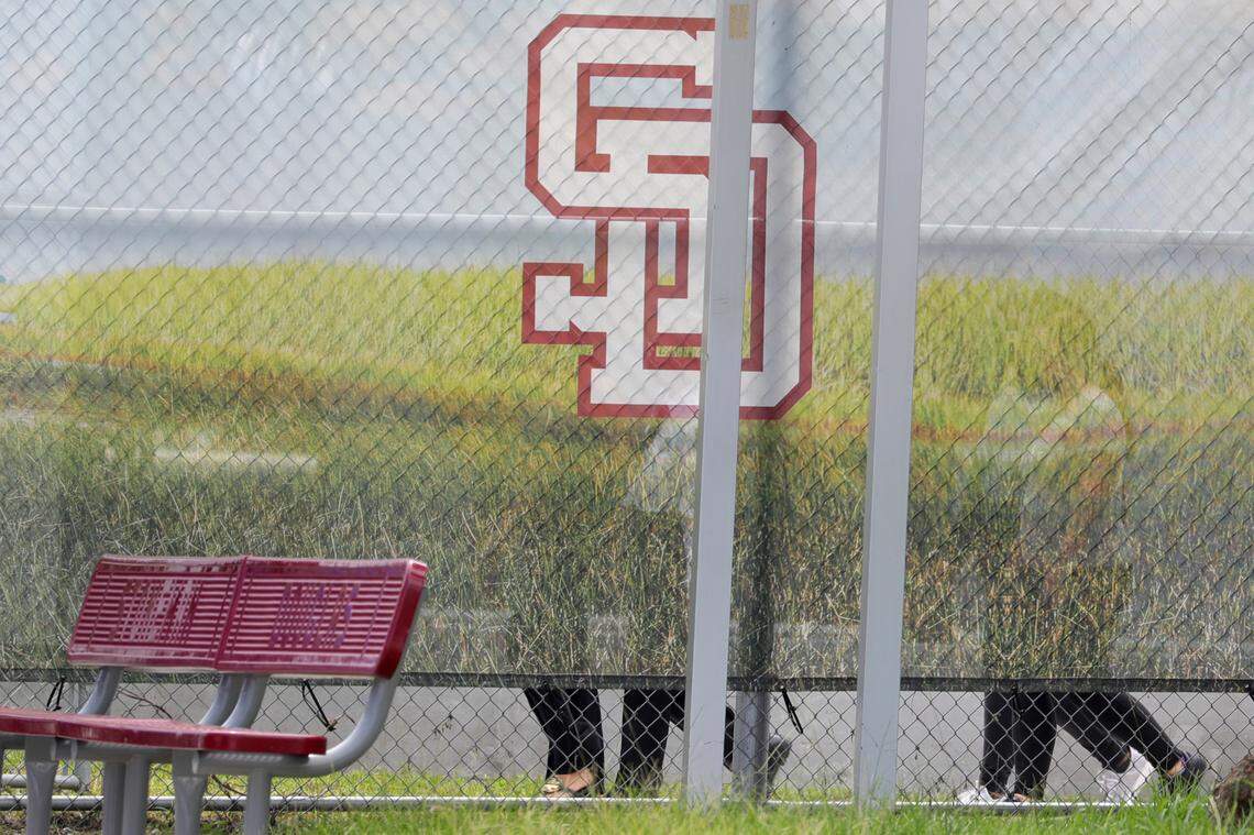 Jurors walk around the “1200 building,” the crime scene where the 2018 shootings took place, at Marjory Stoneman Douglas High School in Parkland on Thursday. The jurors, who are serving anonymously, were shielded from public view by a screen with the SD logo of the school.