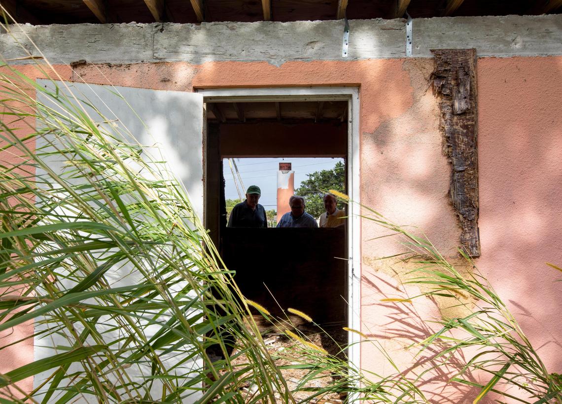 Augusta Greens residents, from left, Julio Lago, Dennis Rice and Morris Henry peer into a bathroom that has fallen into disrepair at the Keys Gate Golf Course on Jan. 10.