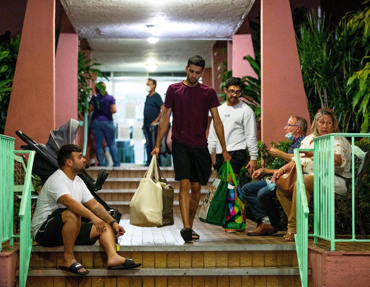 Cristian, the grandson of an elderly resident, carries personal items as all residents from a 138-unit condo at 5050 NW Seventh St. in Flagami were forced to evacuate Aug. 9, 2021, after city officials deemed the building unsafe.