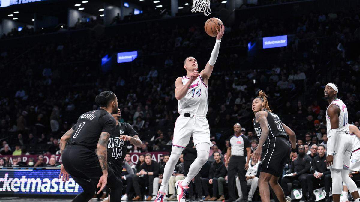 El defensa del Miami Heat, Tyler Herro (14), conduce hacia la canasta mientras es defendido por el base de los Brooklyn Nets, Keon Johnson (45), durante la primera mitad en el Barclays Center.