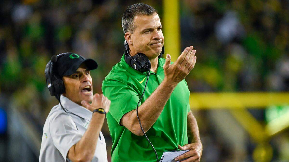 Oregon head coach Mario Cristobal, right, and offensive line coach Alex Mirabal call the Oregon team over aft3er giving up a safety during the third quarter of an NCAA college football game Saturday, Sept. 25, 2021, in Eugene, Ore. (AP Photo/Andy Nelson)