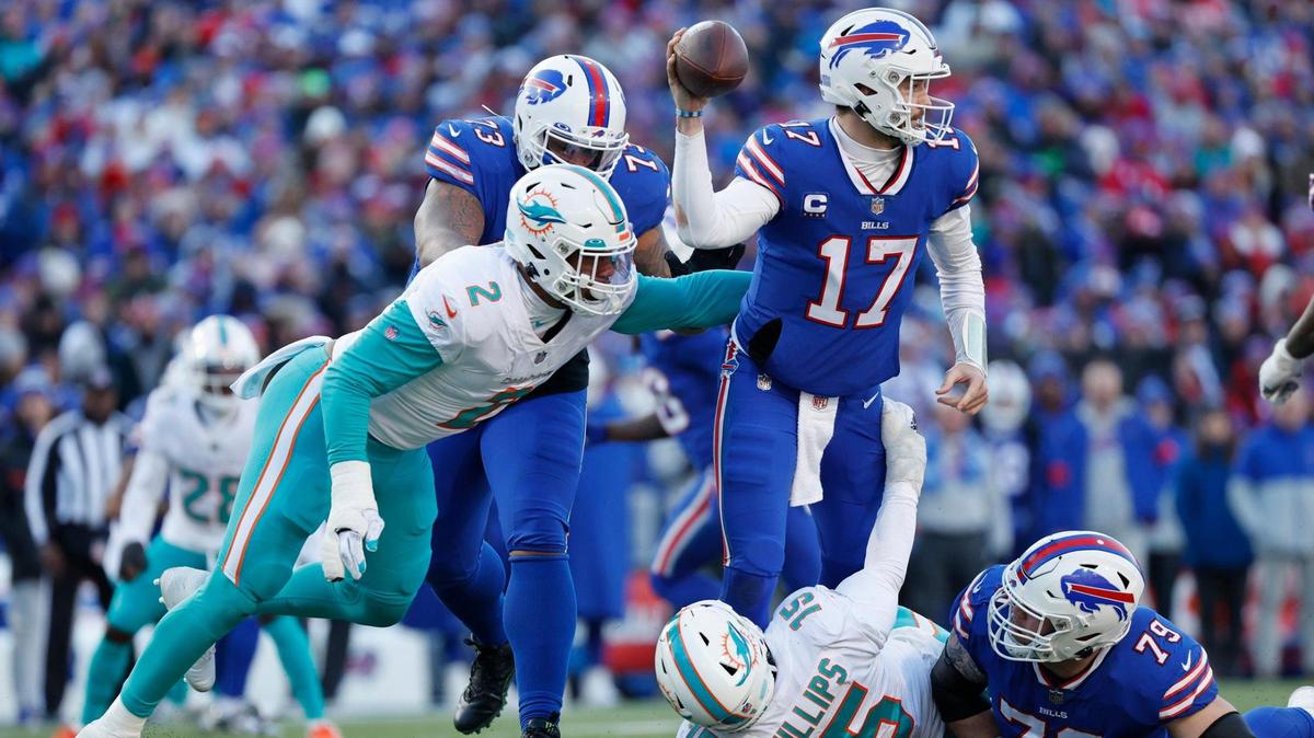 Buffalo Bills quarterback Josh Allen (17) completes a pass despite the pressure by Miami Dolphins linebacker Bradley Chubb (2) and linebacker Jaelan Phillips (15) in the third quarter of the NFL wild-card football game at Highmark Stadium, Orchard Park, NY, on Sunday, January 15, 2023.