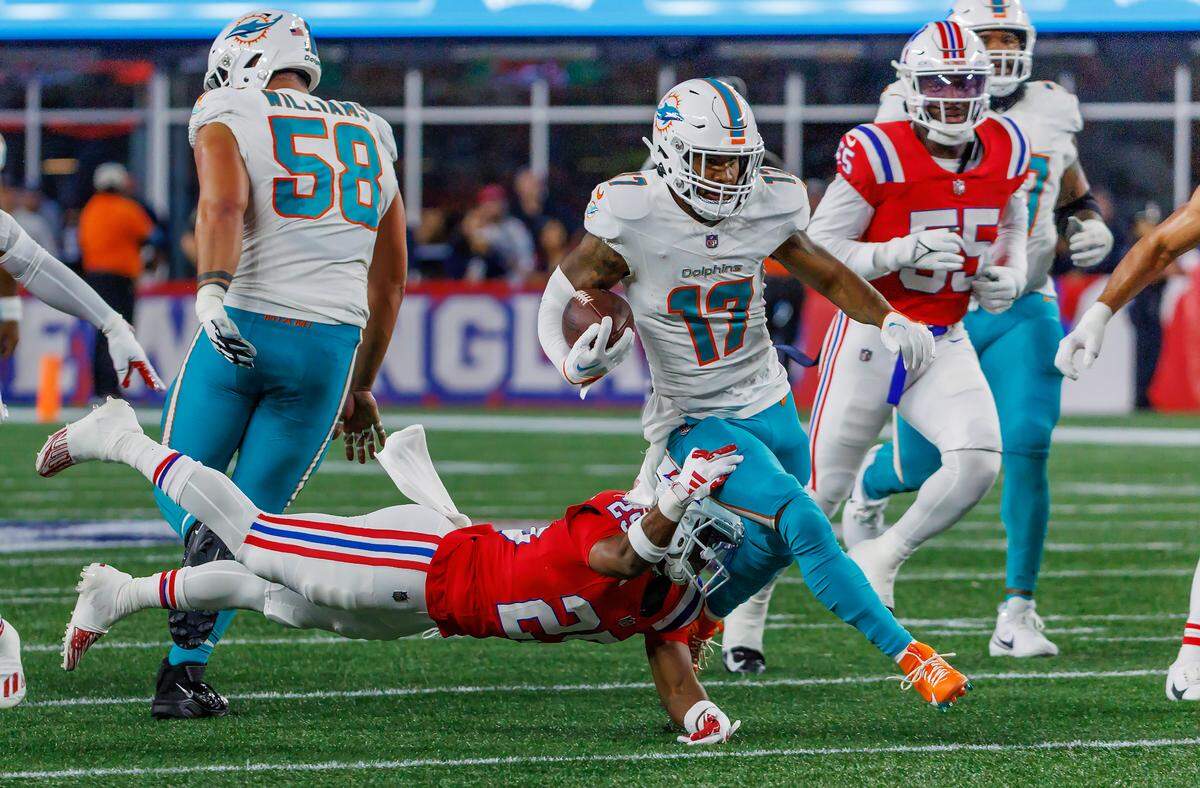 Miami Dolphins wide receiver Jaylen Waddle (17) runs with the football as New England Patriots cornerback Marcus Jones (25) defends during second quarter of an NFL football game at Gillette Stadium on Sunday, Sept. 17, 2023 in Foxborough, MA.