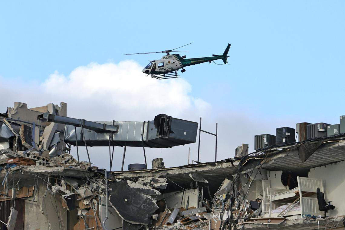 A Miami-Dade Police helicopter flies over the rubble of the Champlain Towers South Condo in Surfside, which collapsed in the early morning hours, wiping away 55 condo units.