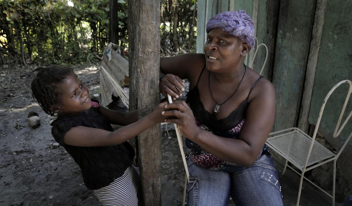 Paula Paul (à droite) et sa fille Marie Stacey (à gauche), six ans, devant leur domicile à Bellanger, une communauté rurale de la basse vallée de l’Artibonite en Haïti. Mme Paul, 44 ans, a été diagnostiquée avec un cancer du col de stade avancé.