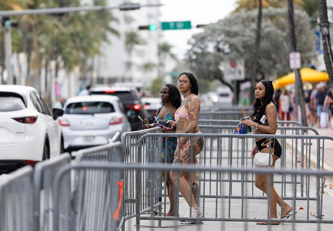Women wait for traffic before crossing Ocean Drive during spring break on Saturday, March 15, 2025, in Miami Beach, Fla.