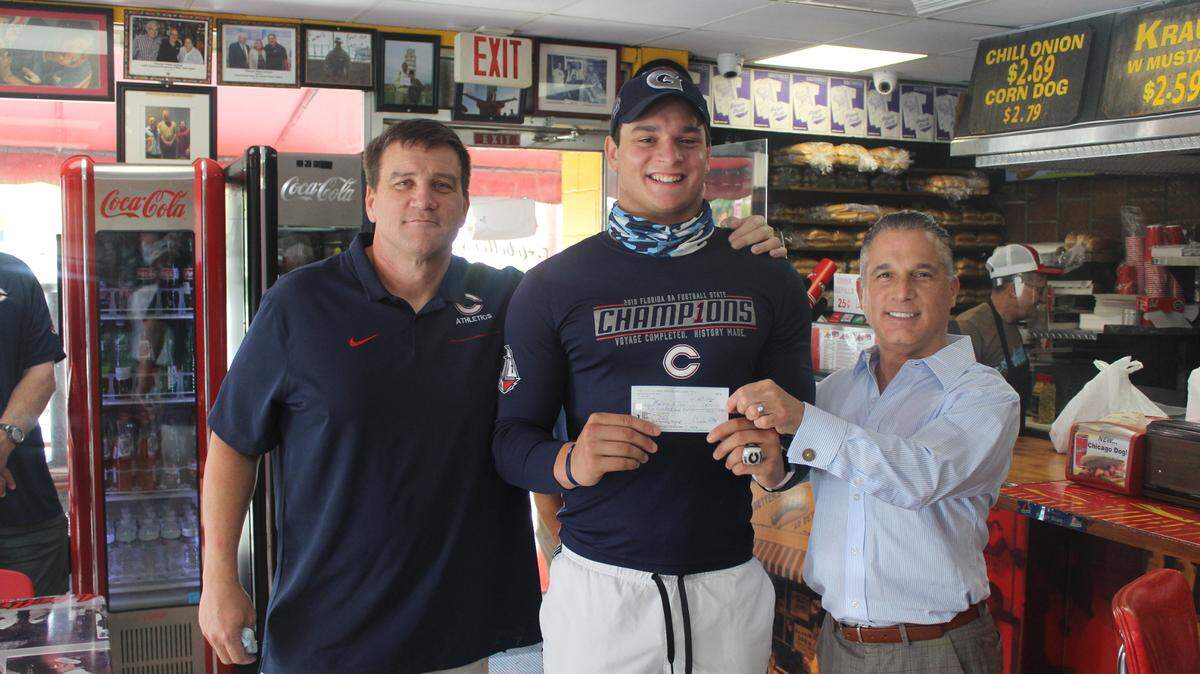 Flanked on the left by his coach David Dunn and Miami Touchdown Club president Gregg Zalkin, on the right, Columbus DE/LB Max Villar was at Arbetter’s Hot Dog restaurant Wednesday morning where he was presented with a check for being named the club’s 2020 Scholar Athlete Award winner.