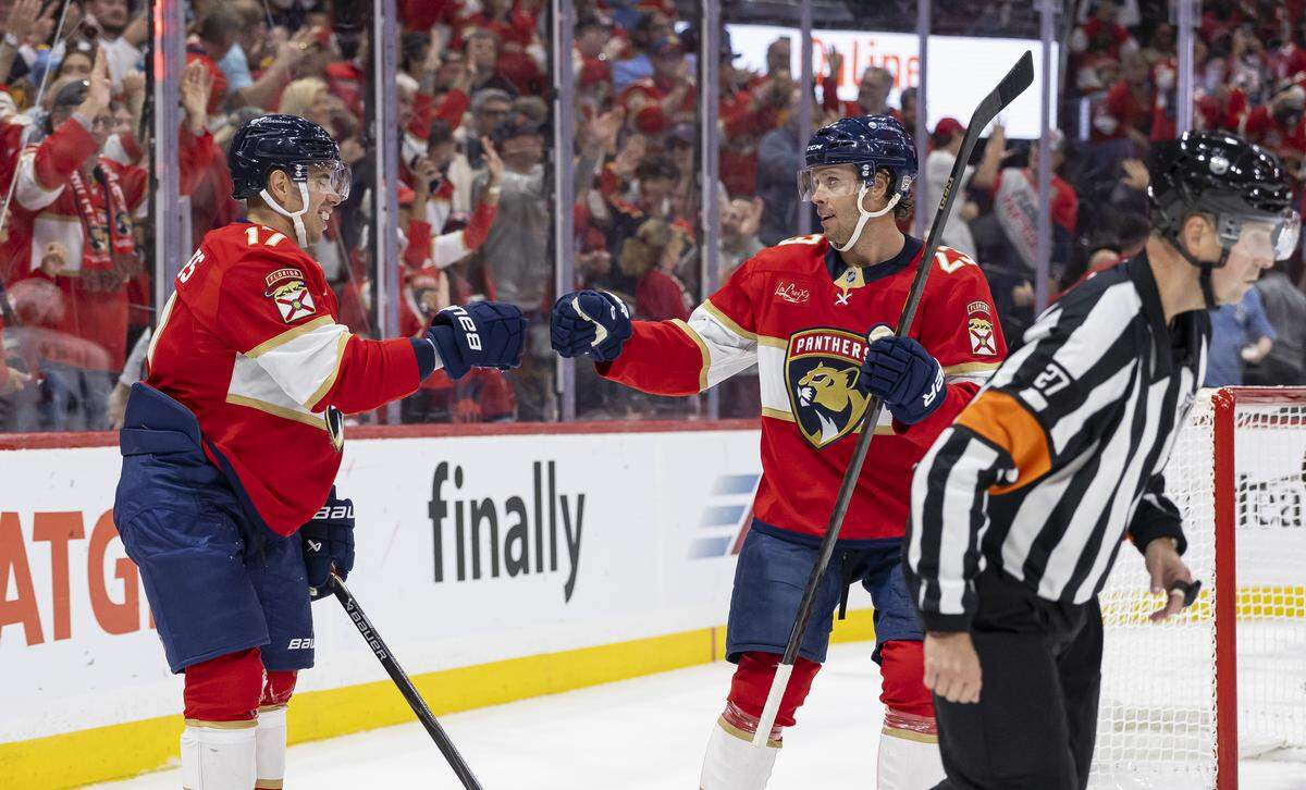 Florida Panthers center Carter Verhaeghe (23) celebrates with center Evan Rodrigues (17) after scoring against Chicago Blackhawks goaltender Spencer Knight (30) in the first period of their NHL game at Amerant Bank Arena on Tuesday, Oct. 7, 2025, in Sunrise, Fla.