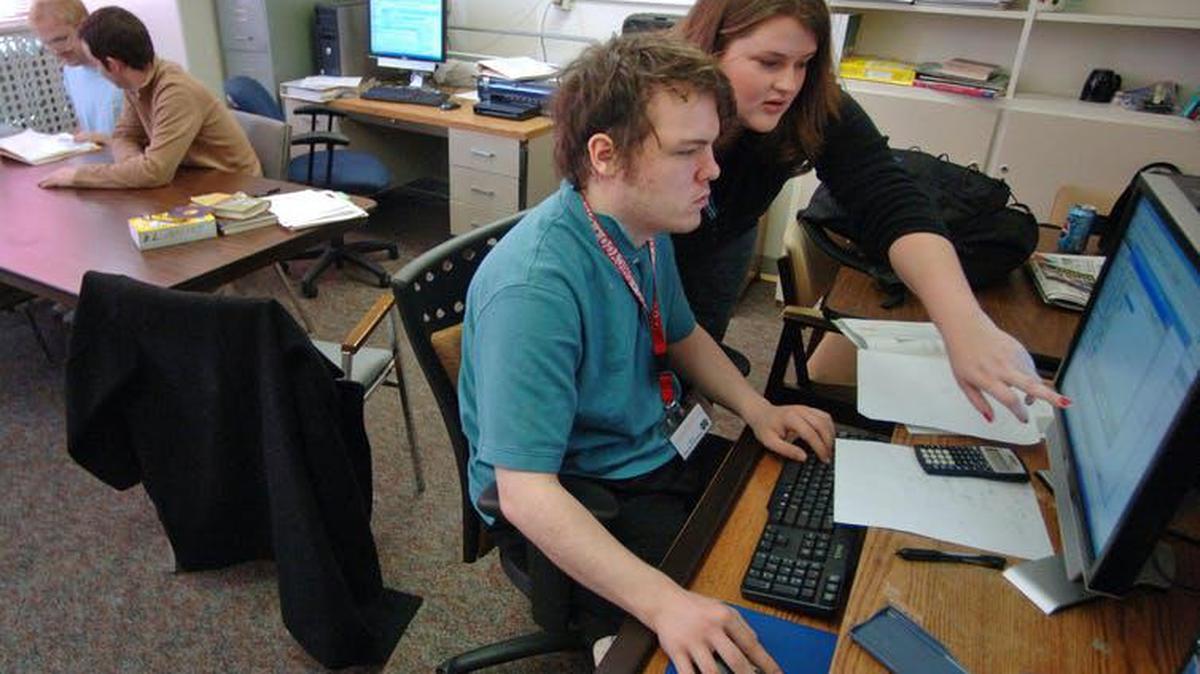 A student and instructor work on skills necessary for college success at the West Virginia Autism Training Center at Marshall University in Huntington, West Virginia.