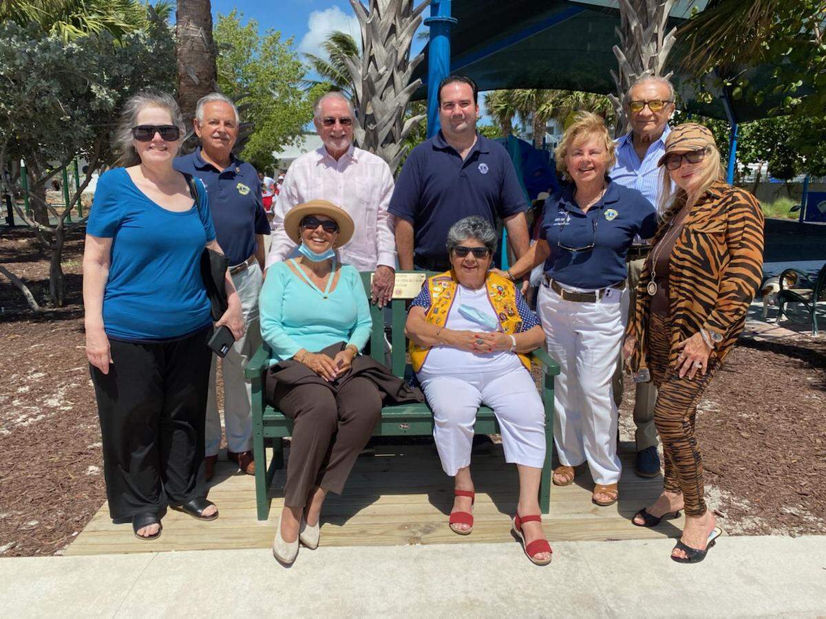 Miami Buena Vista Biltmore Lions Club donated two park benches made from plastic bags they collected. Cathy Triana, Grace Mayo, Teresa Saumell, Mayra Montes, and Alicia Hernandez are pictured in the front row. Behind them are Lions District 35-N Governor Antonio Montes, Juan Tejera, Daniel I. Pedreira, and Freddy Vaca.