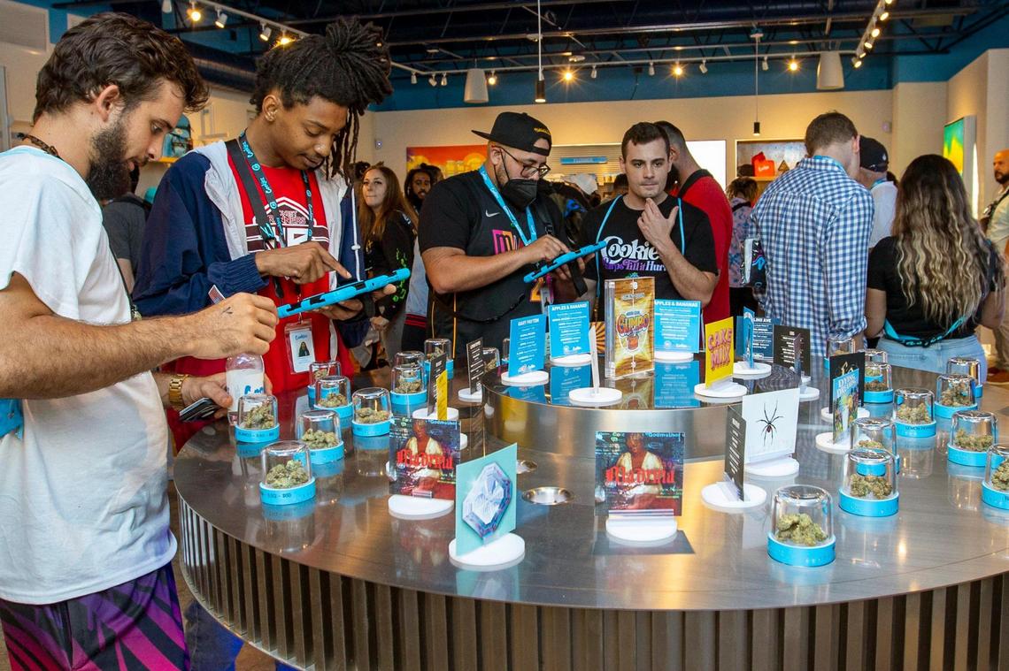 Customers and budtenders look over different strains of marijuana during the grand opening of Cookies Miami, Florida’s first minority-owned marijuana dispensary, in Miami on Saturday, Aug. 13, 2022.