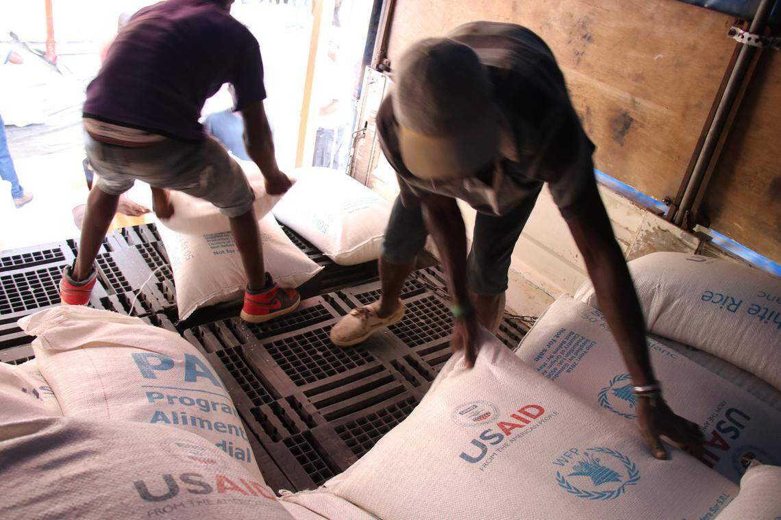 Workers off-load food assistance from trucks at the Chansolme school in northwest Haiti the World Food Program set up a general food distribution point.