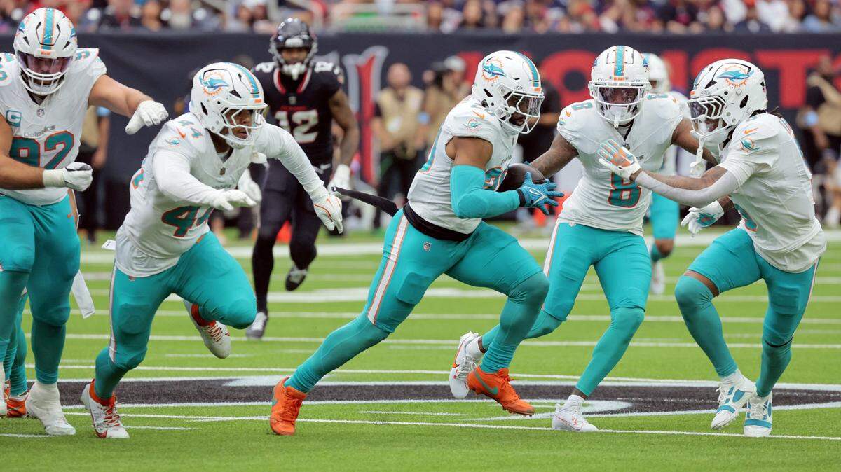 The Miami Dolphins defense scrambles as linebacker Jordyn Brooks (20) picks up a Houston Texans fumble in the first half of their NFL football game at NRG Stadium in Houston, Texas, on Sunday, December 15, 2024.