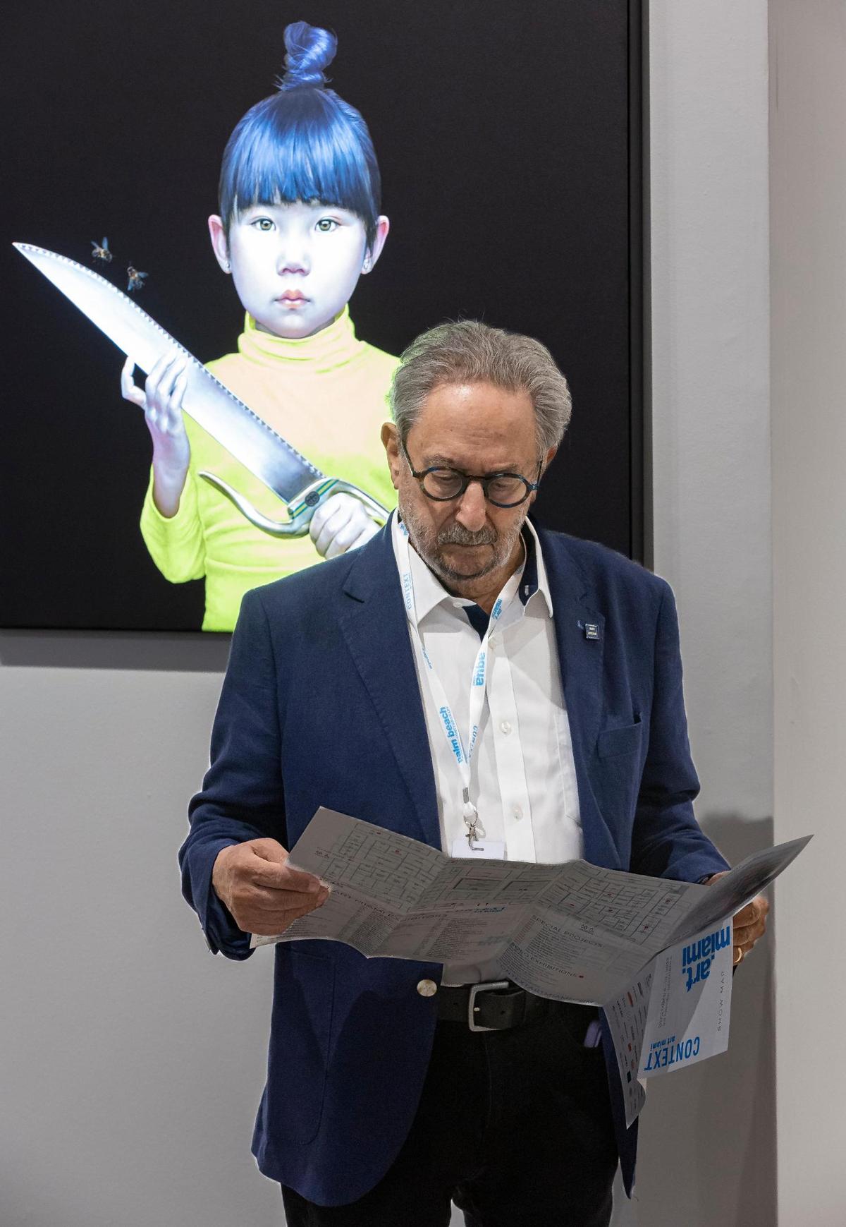 Raymond S. Elman looks at show floor map next to Salustiano’s “Tenderness Land” during a VIP preview at Art Miami 2023 on Tuesday, Dec. 5, 2023, in downtown Miami, Fla.