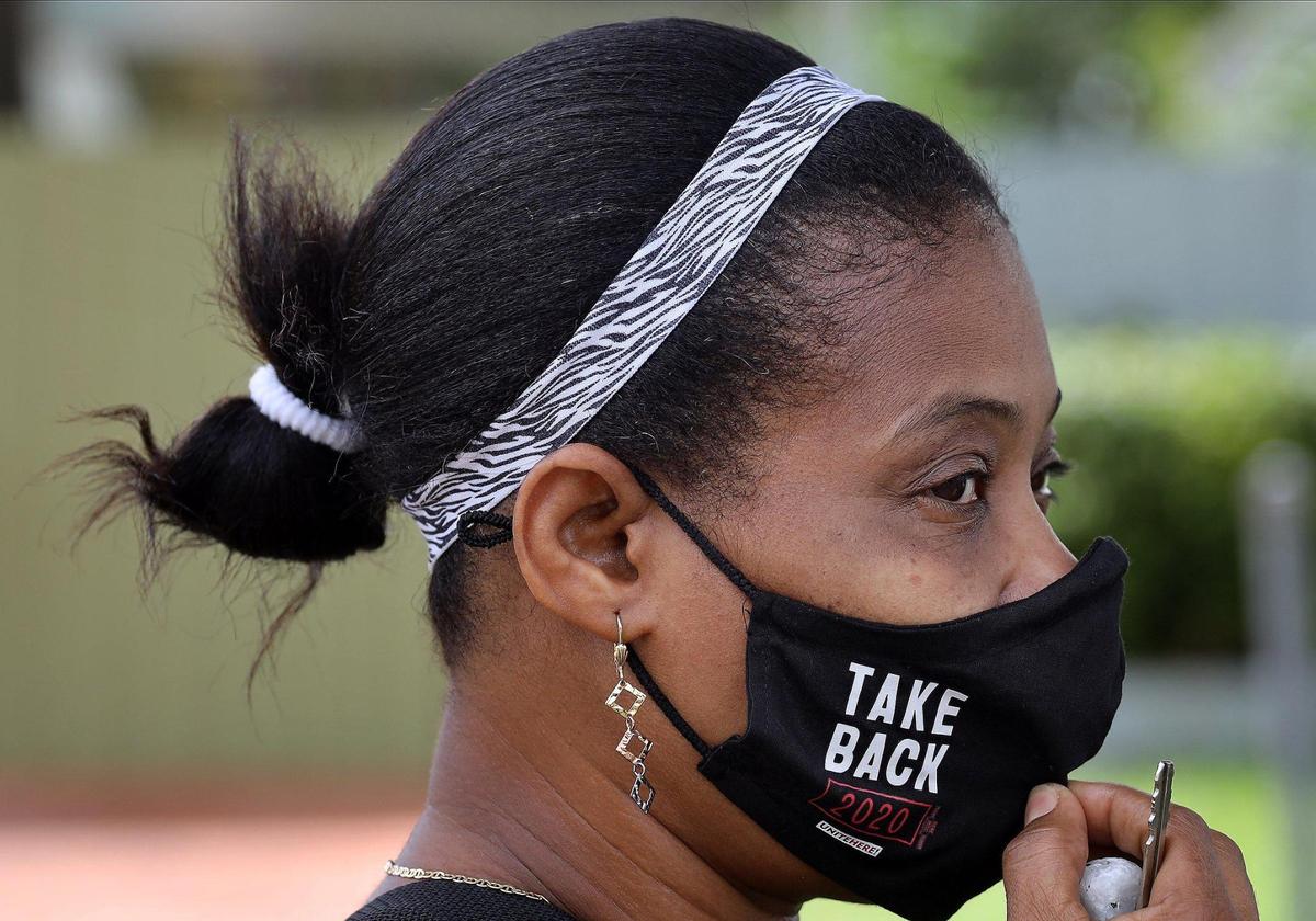 Toussaint Rene pauses as she walks through a North Miami neighborhood while canvassing with other members of Unite Here, a Local 355 union office, for the Biden campaign on Sunday, October 4, 2020.